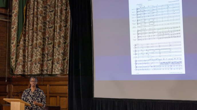 Sonita Alleyne indicating a slide showing the Overture to Don Giovanni