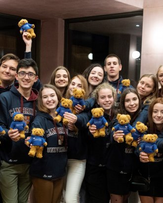 20 visiting Ukrainian medical students posing with Cambridge University hoodies and Homerton College teddy bears