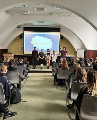 Students talking to prospective students in a large room 